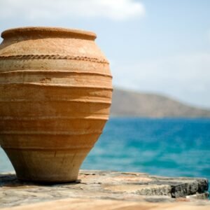 brown clay pot on white sand near body of water during daytime